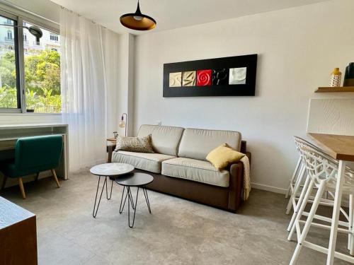 un salon avec un canapé et une table dans l'établissement Bd Grosso apt 4 prs, 300m plage, clim, parking, à Nice