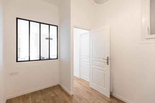 Cette chambre blanche dispose d'une porte et d'une fenêtre. dans l'établissement Castellane centre ville : Deux Chambres, à Marseille