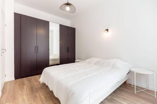 une chambre blanche avec un grand lit et une table dans l'établissement Castellane centre ville : Deux Chambres, à Marseille