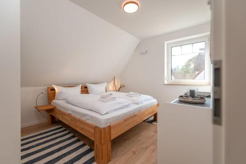 a bedroom with a bed with white sheets and a window at Ferienhaus "Reet-Traum" in Zirchow
