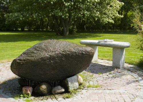 a rock sitting next to a stone bench at Aparthotel Friesenhof in Wenningstedt