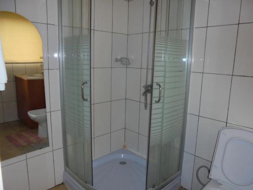 a glass shower in a bathroom with a toilet at Kigali Diplomat Hotel in Kigali