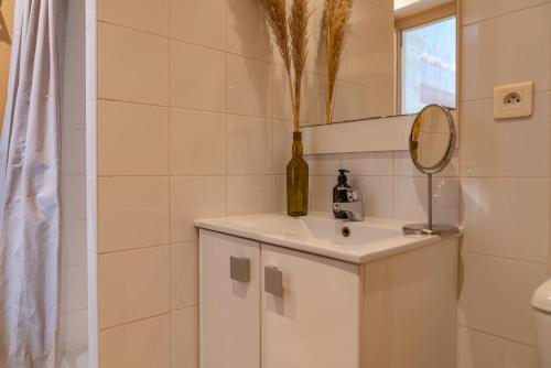 une salle de bain avec un lavabo et un miroir dans l'établissement La Cabane Camarguaise en centre ville - Une Nuit à Nîmes, à Nîmes