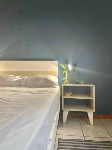 a bedroom with a white bed and a night stand at Anana Coliving in Playa del Carmen