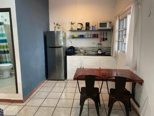 a kitchen with a wooden table and a refrigerator at Anana Coliving in Playa del Carmen