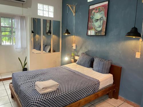 a bedroom with a bed in a blue wall at Anana Coliving in Playa del Carmen