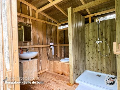 a wooden bathroom with a sink and a shower at Parc animalier du Hérisson in Doucier