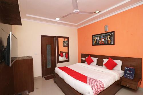 a bedroom with a large bed with red pillows at OYO 16147 Hotel Jyoti Continental Agra in Tājganj