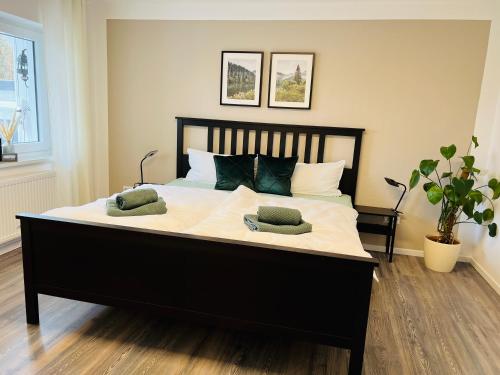 una camera da letto con un grande letto con due cuscini sopra di Ferienwohnung Schwarzwald Lodge a Schömberg