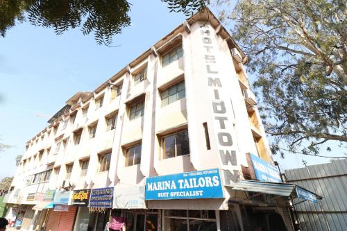 un edificio blanco con un cartel en el costado en Flagship Hotel Midtown, en Bhopal