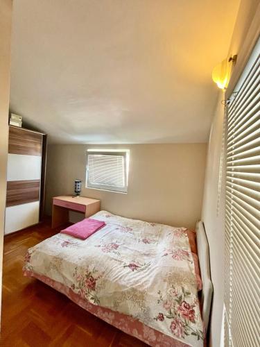 a small bedroom with a bed and a window at Apartman Guberinic,Tivat ,trosoban stan in Tivat