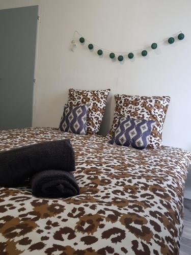 a bed with a brown and white blanket and pillows at St junien n:2 in Saint-Junien