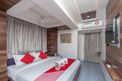 een slaapkamer met een groot bed met rode kussens bij Capital O Admire Suit Hospitality in Chennai