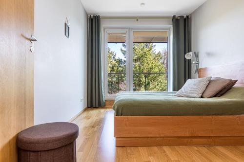 sypialnia z łóżkiem i dużym oknem w obiekcie Nature - Vanagupės apartamentai w Połądze