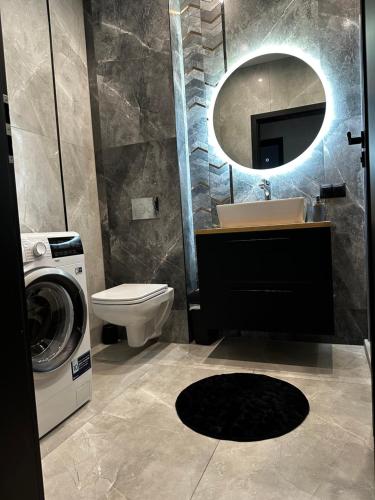 a bathroom with a sink and a washing machine at Apartament u Heleny in Sosnówka