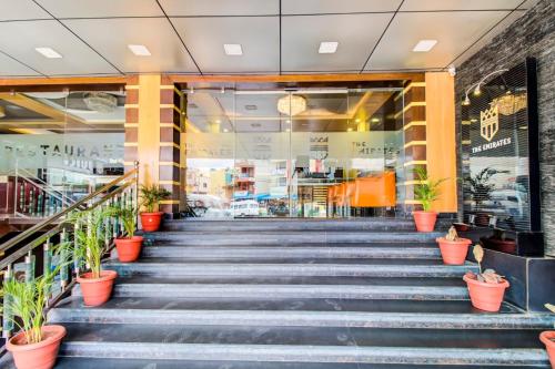 a set of stairs in a store with potted plants at Capital O 5381 The Emirates Hotel in Bangalore