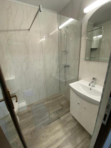 a bathroom with a shower and a sink and a mirror at Apartament olimp 2 camere in Olimp