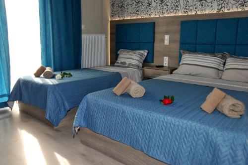 a bedroom with two beds with blue sheets at Senia Holidays in Preveza