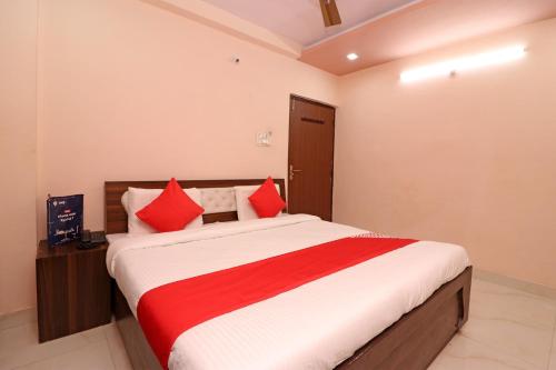 Tīrath的住宿－Flagship Hotel Royal Paradise，一间卧室配有一张带红色枕头的大床