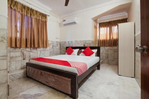 a bedroom with a bed with red pillows at Hotel Holiday Rani Gunj Opp Punjab national bank in Secunderabad