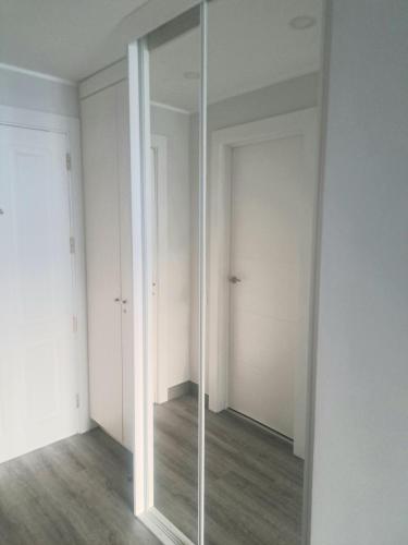 a mirror in a room with white walls and wooden floors at A&V Studio in Green Park in San Miguel de Abona