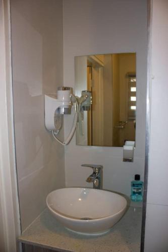 a white sink in a bathroom with a mirror at A homely and secure 2 bedroom with uncapped Wifi in Johannesburg
