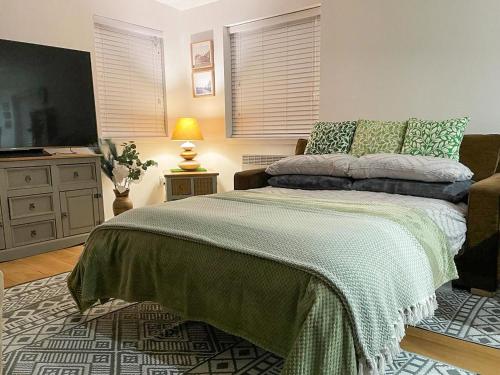 een slaapkamer met een bed en een flatscreen-tv bij Orchard Chalet in Arnhall