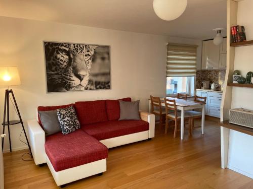 a living room with a red couch and a table at Happy Viesturs in Valmiera