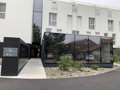 un edificio con un gran edificio de cristal con coches en ** Studio cosy La Rochelle quartier des Minimes **, en La Rochelle