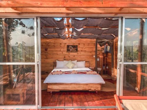a bedroom in a log cabin with a bed at Foresight Eco Lodge & Safari in Karatu