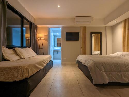 1 dormitorio con 2 camas y TV de pantalla plana en Hedonism apartments en Mar del Plata