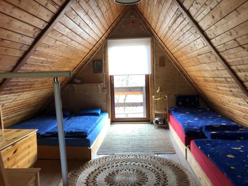 a room with two beds in a wooden cabin at Domek Jakusówka Laliki Pochodzita w sercu Beskidów in Laliki