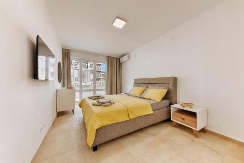 a bedroom with a bed with a yellow blanket on it at MonteCasa Seaview Rooms in Dobra Voda