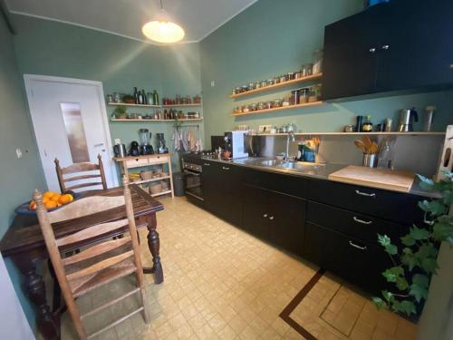 a kitchen with a counter and a sink and a table at Superbe appartement avec jardin, sauna et jacuzzi in Brussels