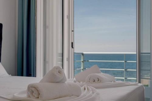 a bedroom with two beds with towels and a view of the ocean at Privilegio Studio 2 in Kanali
