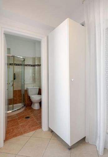 a bathroom with a toilet and a glass shower stall at Privilegio Studio 2 in Kanali