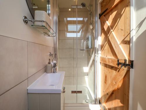 a bathroom with a sink and a shower at Admiral Cottage in Woodbridge