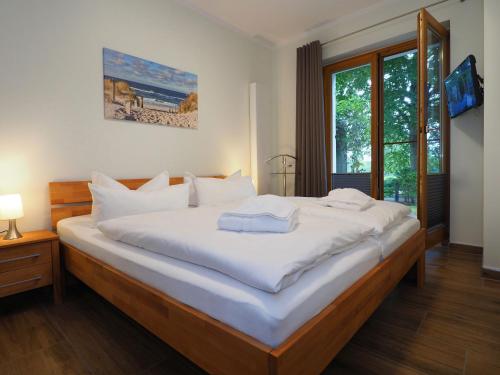 a bedroom with a large bed with white sheets at Kaiservillen Heringsdorf - 2-Raum-Ferienwohnung mit 1 Schlafzimmer und Terrasse DG22 in Heringsdorf