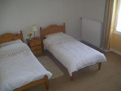 a bedroom with two beds and a night stand and a window at 9 Guests - Pet Friendly in rural West France in Clussais-la-Pommeraie