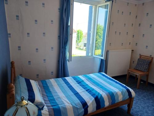 1 dormitorio con cama y ventana grande en Lovely 4-Bed House in rural West France, en Clussais-la-Pommeraie
