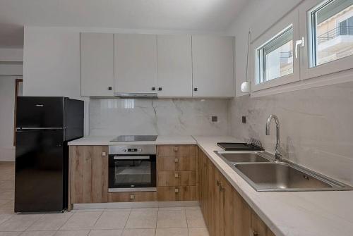 a kitchen with a black refrigerator and a sink at Privilegio Studio 3 in Kanali