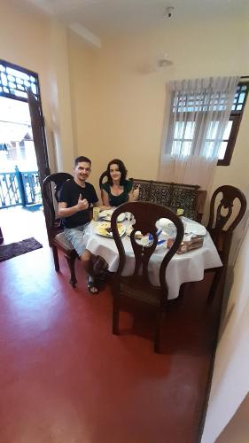 un hombre y una mujer sentados en una mesa en Little Apartment, en Galle