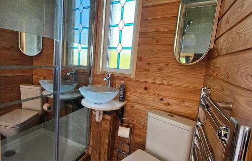 a bathroom with two sinks and a toilet at Wye Valley Cabin in Upper Welson