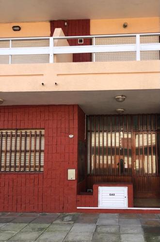 un edificio con una pared de ladrillo rojo y balcón en SOL Y PLAYA STA en Santa Teresita