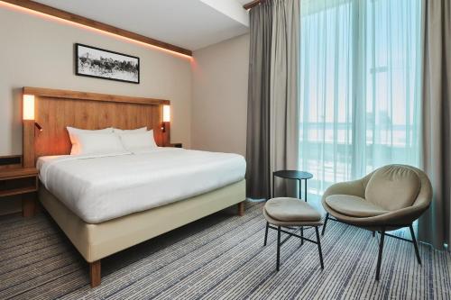a hotel room with a bed and a chair at Courtyard by Marriott Warsaw Airport in Warsaw