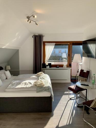a bedroom with a bed and a desk and a window at Haus Kaiser Ferienwohnung und Appartementvermietung in Büsum