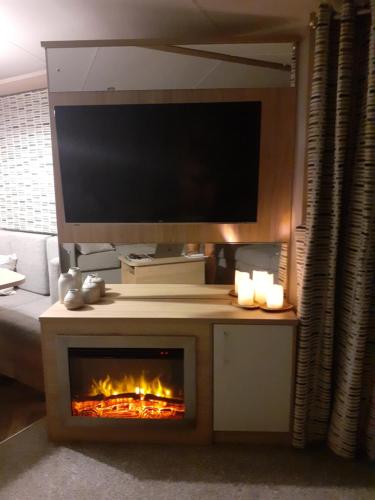 sala de estar con TV y chimenea en Golden Sands Retreat en Mablethorpe