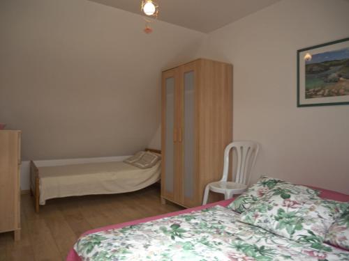 a bedroom with a bed and a cabinet and a chair at Maison de qualité avec jardin paysager à Sauzon - FR-1-418-38 in Sauzon