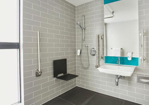 La salle de bains est pourvue d'un lavabo et d'une douche. dans l'établissement Holiday Inn Express - Fleet, an IHG Hotel, à Fleet
