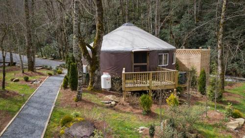 a yurt in the woods next to a path at Tranquil Haven Luxy Yurt - Creekside Glamping with Private Hot Tub in Topton